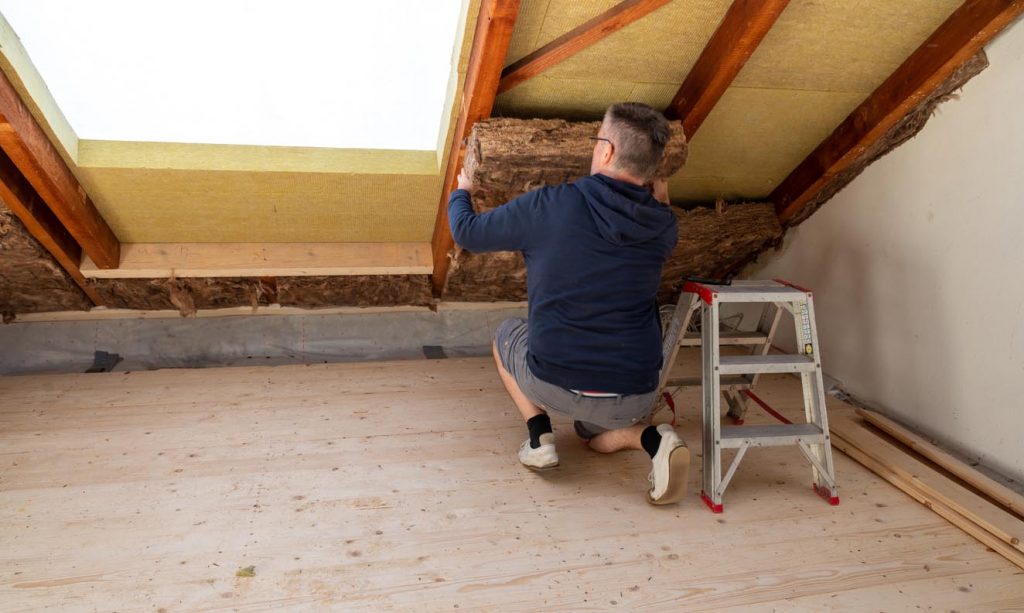 Un homme fait l'isolation des murs