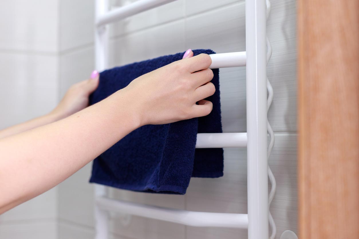 Une femme met une serviette sur un sèche serviette