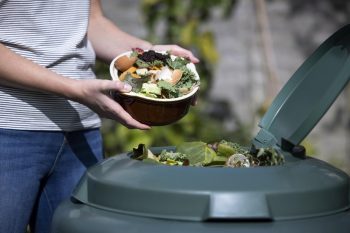 Un homme met des déchets dans le compost