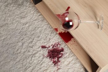 Verre de vin renversé sur tapis beige