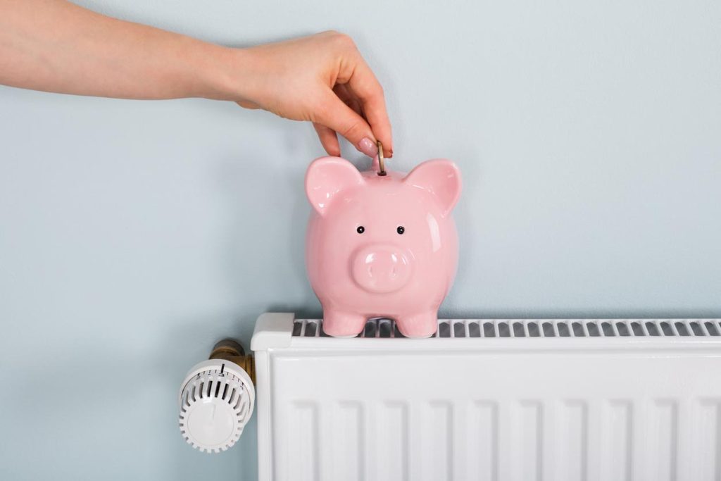 Concept d'économie sur le chauffage avec une tirelire sur le radiateur