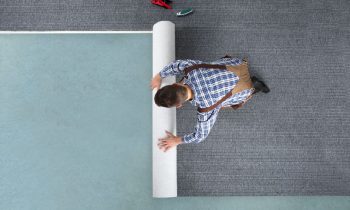 Homme Au Sol Qui Déroule Une Moquette Neuve