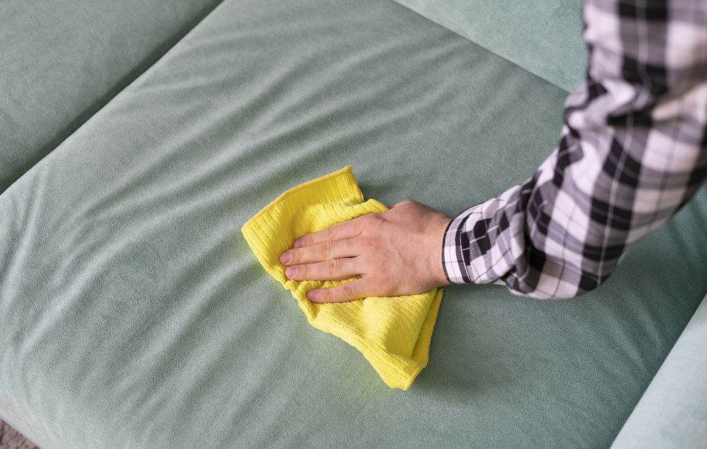 Homme Nettoie Un Canapé En Tissu à L'aide D'une Lingette