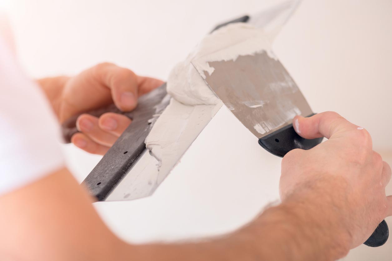 Homme applique du Tadelakt sur sa spatule