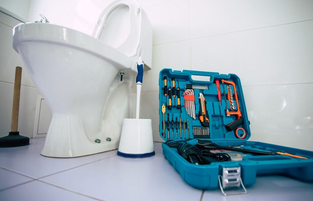 Vue En Contre Plongée De Toilettes, à Coté Une Caisse à Outils
