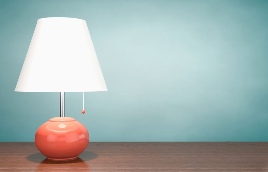 Lampe à Poser Sur Une Suface En Bois Qui Est Allumée Et Consomme De L'électricité