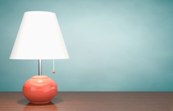 Lampe à Poser Sur Une Suface En Bois Qui Est Allumée Et Consomme De L'électricité