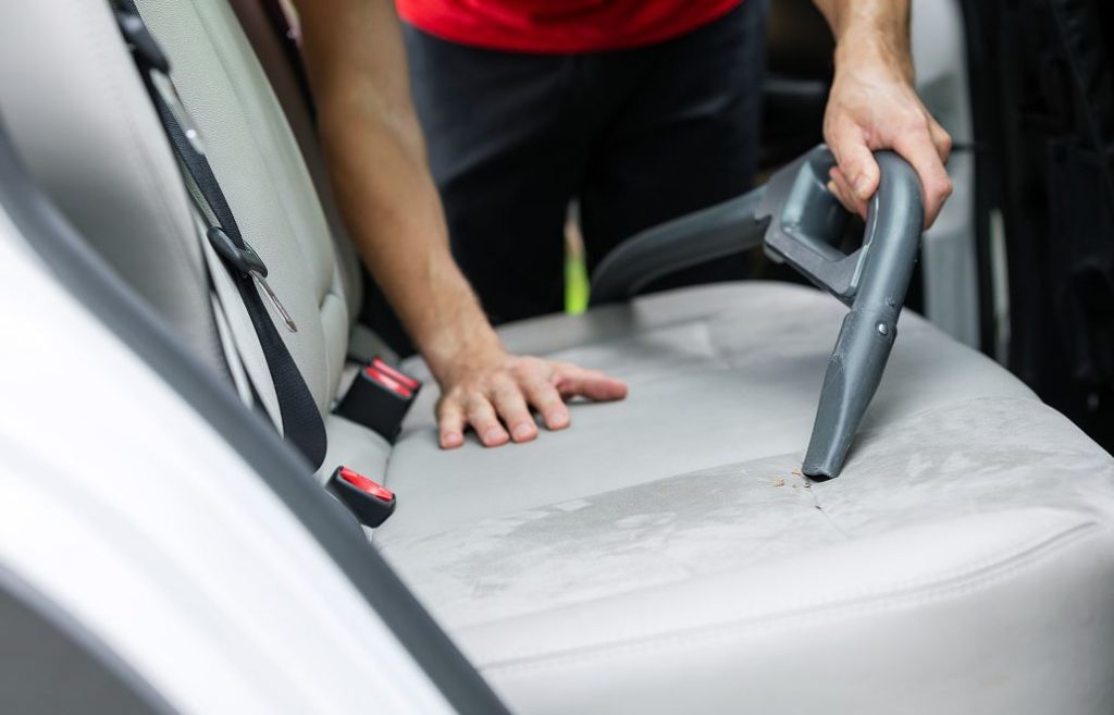 Personne Qui Nettoie L'intérieur De Sa Voiture Avec Un Aspirateur